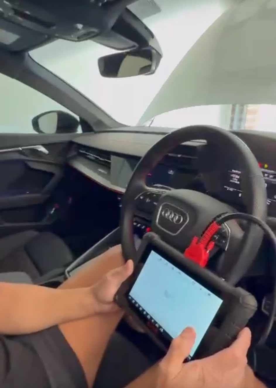 Technician running a diagnostic scan inside a modern vehicle