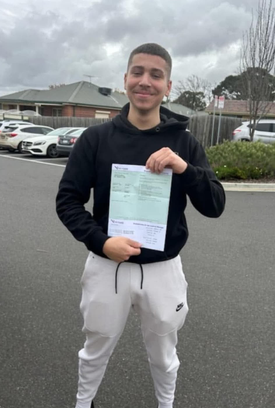 Learner driver holding their VicRoads pass certificate